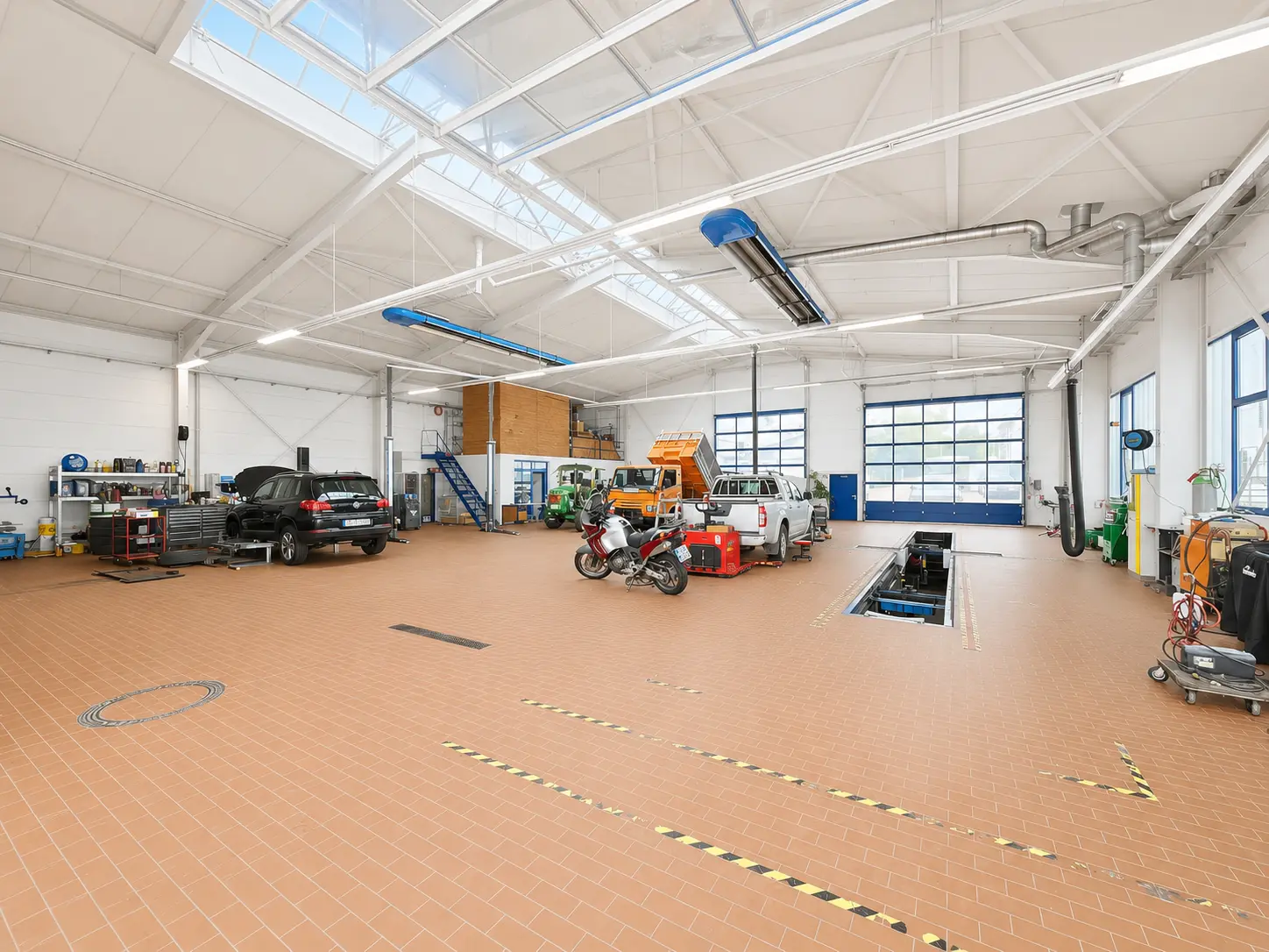 ENZ Werkstatthalle mit Glasdach und verschiedenen Fahrzeugen in Weitwinkel-Perspektive