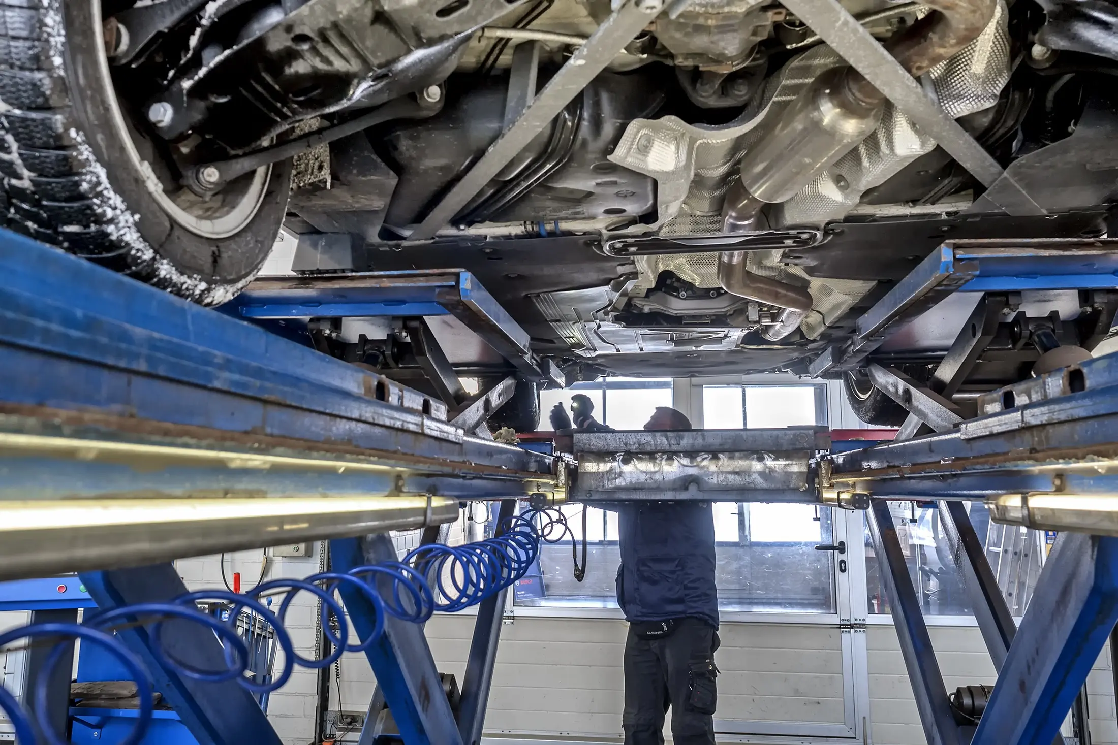 Mechaniker bei der Fahrzeuguntersuchung an der Hebebühne in der ENZ Werkstatt