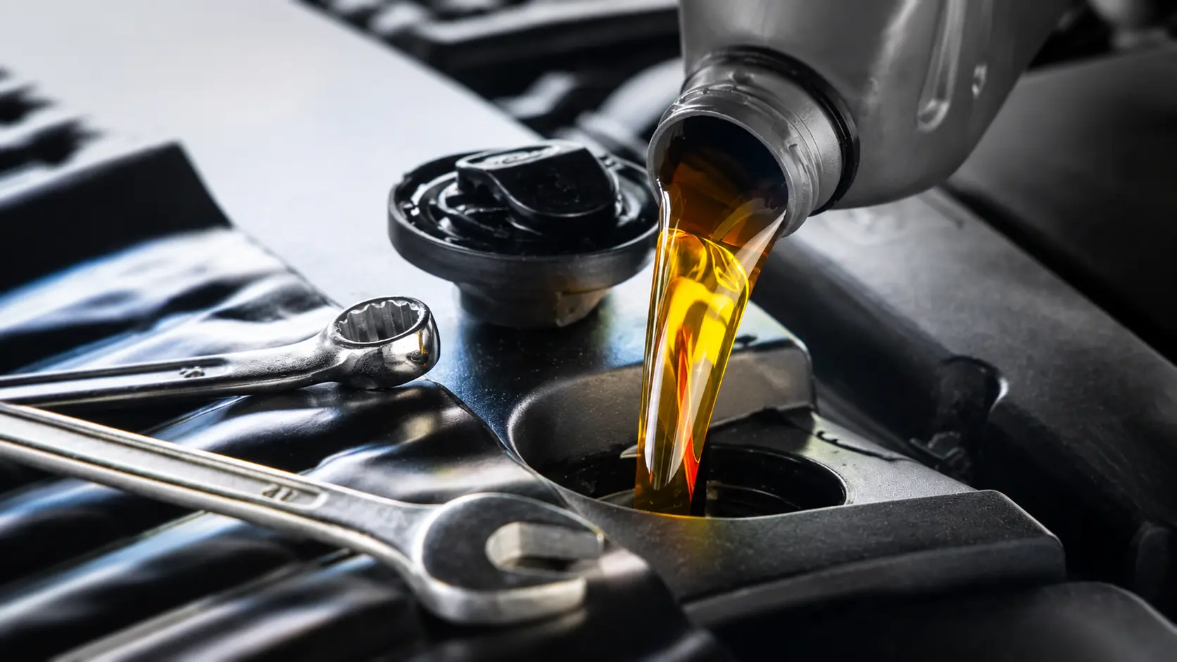 Motoröl wird in einen Motor eingefüllt mit Schraubenschlüsseln in der ENZ Werkstatt